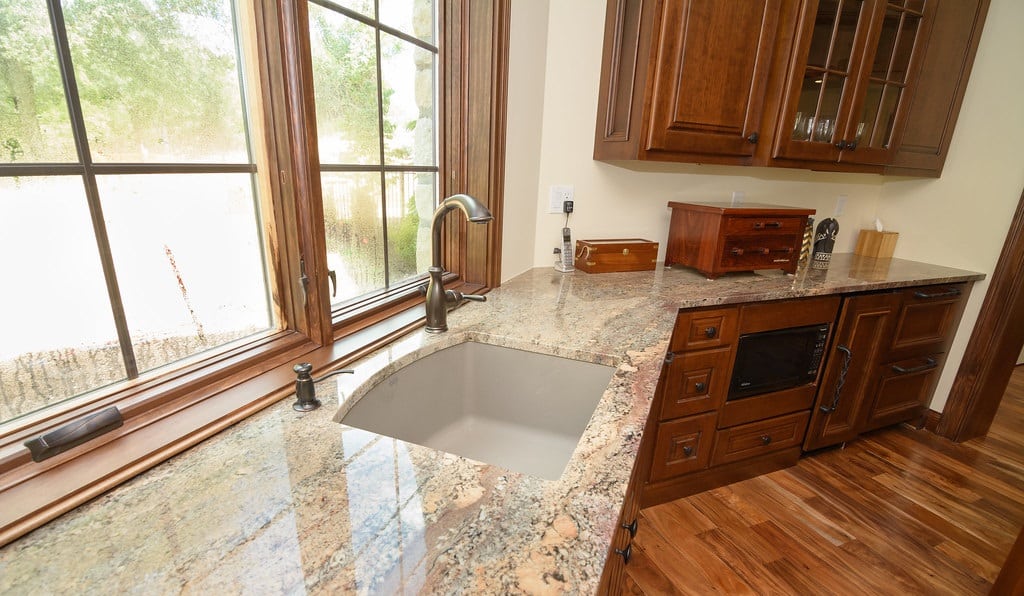 Kitchen with details in wood and brown granite countertop.
