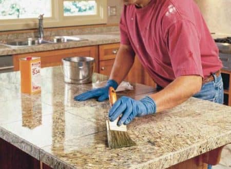 Person applying sealer to a granite countertop.